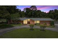 Charming single-story brick home featuring a circular driveway and mature landscaping at 1852 Ne 39Th Ct, Ocala, FL 34470