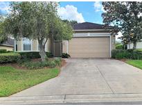 Charming single-story home with a well-manicured lawn, a two-car garage, and mature trees at 2515 Se 19Th Cir, Ocala, FL 34471