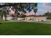 Stunning white home featuring a red tile roof, expansive lawn and circular driveway at 6381 Sw 21St Court Rd, Ocala, FL 34471