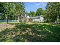 Inviting two-story home featuring a covered front porch, lush lawn, and manicured landscaping at 645 Sw 48Th Ln, Ocala, FL 34471