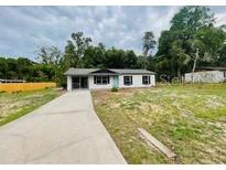 Charming single-story home featuring a well-maintained lawn, long driveway, and mature trees at 6820 Se 108Th St, Belleview, FL 34420