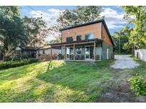 Inviting exterior view of a two-story home with a covered patio and a spacious lawn at 754 Se 167Th Court Rd, Silver Springs, FL 34488