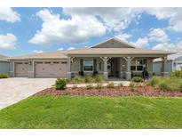 Charming single-story home with manicured front yard, covered porch, and three-car garage at 9577 Sw 82Nd Street Rd, Ocala, FL 34481
