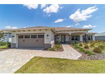 Charming one-story home featuring a brick driveway, a two-car garage, and well-manicured landscaping at 10451 Sw 98Th Place Rd, Ocala, FL 34481