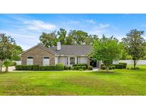 Beautiful single-story home with stone accents, mature landscaping, and lush green lawn at 1107 Se 49Th Ave, Ocala, FL 34471