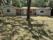 Charming single-story home featuring a covered front porch and stone accents, nestled among mature trees at 312 Nw 28Th St, Ocala, FL 34475