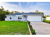 Charming single-story home featuring well-manicured lawn, two car garage, and inviting front entrance at 3897 Sw 169Th Lane Rd, Ocala, FL 34473