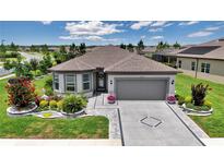 Charming single-story home with a well-manicured lawn and a gray two-car garage at 5634 Sw 91St Ave, Ocala, FL 34481