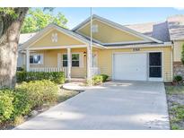 Charming yellow single-story home featuring a covered front porch, one-car garage, and well-maintained landscaping at 8710 Sw 91St Pl # B, Ocala, FL 34481