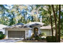 Charming one-story home with a two-car garage and inviting front entrance, nestled among mature trees at 8735 Sw 192Nd Court Rd, Dunnellon, FL 34432