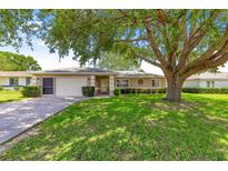 Charming single-story home features a well-manicured lawn, a covered entryway, and an attached two-car garage at 10016 Sw 62Nd Cir, Ocala, FL 34476