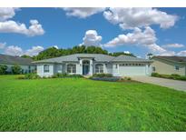 Well-manicured lawn and landscaping frame this attractive single-story home with an attached two car garage at 11147 Sw 53Rd Cir, Ocala, FL 34476