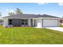 Charming single-story home featuring a gray accent wall and a well-manicured lawn at 16697 Sw 30 Avenue Rd, Ocala, FL 34473