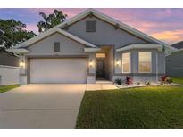 Charming single-story home showcasing a well-manicured lawn and inviting front entrance at dusk at 181 Nw 45Th Loop, Ocala, FL 34475