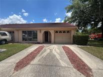 Inviting single-story home with tile roof, attached garage, tidy landscaping and attractive front yard at 1910 Sw 34Th Ct, Ocala, FL 34474