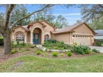 Charming single-story home with a lush landscaped front yard and inviting arched entryway at 19586 Sw 84Th Pl, Dunnellon, FL 34432