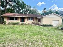 Charming single-story home featuring an attached garage and well-established lawn at 2220 Ne 3Rd St, Ocala, FL 34470