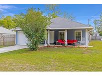 Inviting home featuring a cozy front porch seating area, landscaped garden bed, and ample natural light at 30 Bahia Trace Loop, Ocala, FL 34472