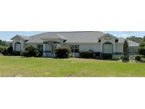 Charming single-story home featuring a well-manicured lawn and beautiful landscaping at 6925 Nw Highway 225A, Ocala, FL 34482