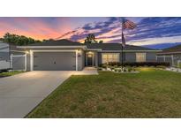 Charming one-story home with a well-manicured lawn and an American flag at 7442 Sw 129Th Ln, Ocala, FL 34473
