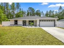Charming single-story home featuring a freshly manicured lawn and a two-car garage at 15350 Sw 30Th Street, Ocala, FL 34481