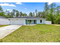 Charming single-story home featuring a fresh lawn, a two-car garage, and decorative landscaping at 15368 Sw 30Th St, Ocala, FL 34481