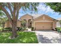 Charming single-story home with a well-manicured lawn, lush landscaping and a 2 car garage at 2434 Walnut Heights Rd, Apopka, FL 32703
