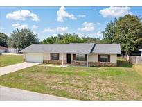 Charming single-story home featuring stone accents, a well-maintained lawn, and an attached one-car garage at 4331 Se 106Th Pl, Belleview, FL 34420