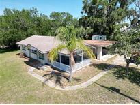 Charming single-story home with a screened porch and a mature palm tree in the front yard at 705 Washington Ave, Eustis, FL 32726
