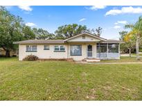 Charming single-story home with a screened-in porch and well-maintained lawn at 705 Washington Ave, Eustis, FL 32726