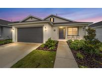 Charming single-story home with a well-manicured lawn and a two-car garage, inviting front porch with seating area at 7224 Sw 61St Pl, Ocala, FL 34474