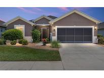 Charming home exterior with a manicured lawn and a two-car garage, great curb appeal and design at 7333 Sw 98Th Ct, Ocala, FL 34481