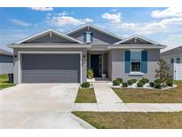 Charming single-story home with a gray exterior, blue shutters, and a well-manicured front yard at 7571 Sw 64Th Street Rd, Ocala, FL 34474