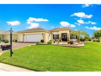 Charming home featuring a well-manicured lawn and attractive landscaping at 11871 Se 91St Cir, Summerfield, FL 34491