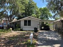 Cozy home features a covered carport, screened porch, and tidy landscaping at 119 Lockhart St, Daytona Beach, FL 32114