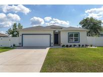 Charming single-story home featuring a well-manicured lawn, white exterior, and an attached two-car garage at 14055 Sw 30Th Terrace Rd, Ocala, FL 34473