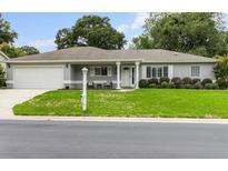 Charming single-story home featuring a well-manicured lawn, neutral paint, and a welcoming front porch at 14481 Sw 112Th Cir, Dunnellon, FL 34432