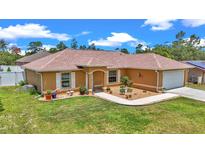 Charming single-story home featuring a well-manicured lawn and inviting front garden at 16969 Sw 40Th Cir, Ocala, FL 34473