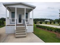 Charming cottage-style home with a cozy porch and well-maintained landscaping in a serene community setting at 4345 Nw 27Th Pl, Ocala, FL 34482