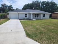 Charming one-story home with a well-manicured lawn and a concrete driveway at 541 56Th Ct, Ocala, FL 34482