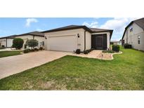 Well-maintained home featuring an attached two-car garage and a screened-in porch at 6051 Sw 93Rd Cir, Ocala, FL 34481