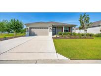 Charming single-story home featuring a well-manicured lawn, a two-car garage, and a welcoming front entrance at 7750 Sw 87Th Ave, Ocala, FL 34481