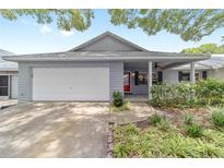 Charming home with a well-manicured lawn, attached garage, and a welcoming red front door at 8745 Sw 92Nd St # B, Ocala, FL 34481