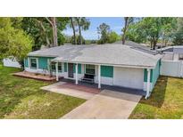 Charming single-story home with a manicured lawn, attached garage, and inviting front porch seating at 111 Almond Rd, Ocala, FL 34472