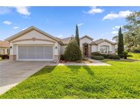 Charming single-story home featuring a well-manicured lawn and an attached two-car garage at 13015 Se 93Rd Cir, Summerfield, FL 34491