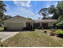 Charming single-story home with a well-maintained lawn and attached two-car garage at 13385 Ne 10Th Ct, Citra, FL 32113