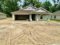 New construction home featuring a two-car garage and concrete block construction at 3131 Ne 46Th Ave, Ocala, FL 34470