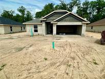 New construction home features concrete block construction, attached two-car garage, and modern architectural details at 3143 Ne 46Th Ave, Ocala, FL 34470