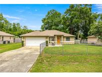 Charming single story home featuring a fenced front yard, attached garage, and a welcoming front sitting area at 5263 Nw 62Nd Nw Ave, Ocala, FL 34482