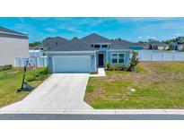 Charming single-story home with a well-maintained lawn and attached two-car garage and a basketball hoop at 5621 Sw 90Th Ln, Ocala, FL 34476
